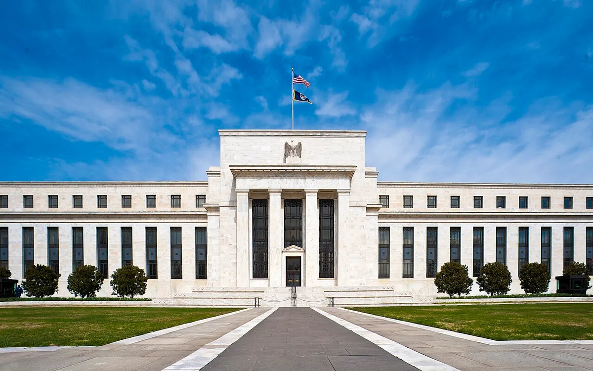 The Marriner S. Eccles Federal Reserve Board Building in Washington, seen down its front walk under a blue sky
